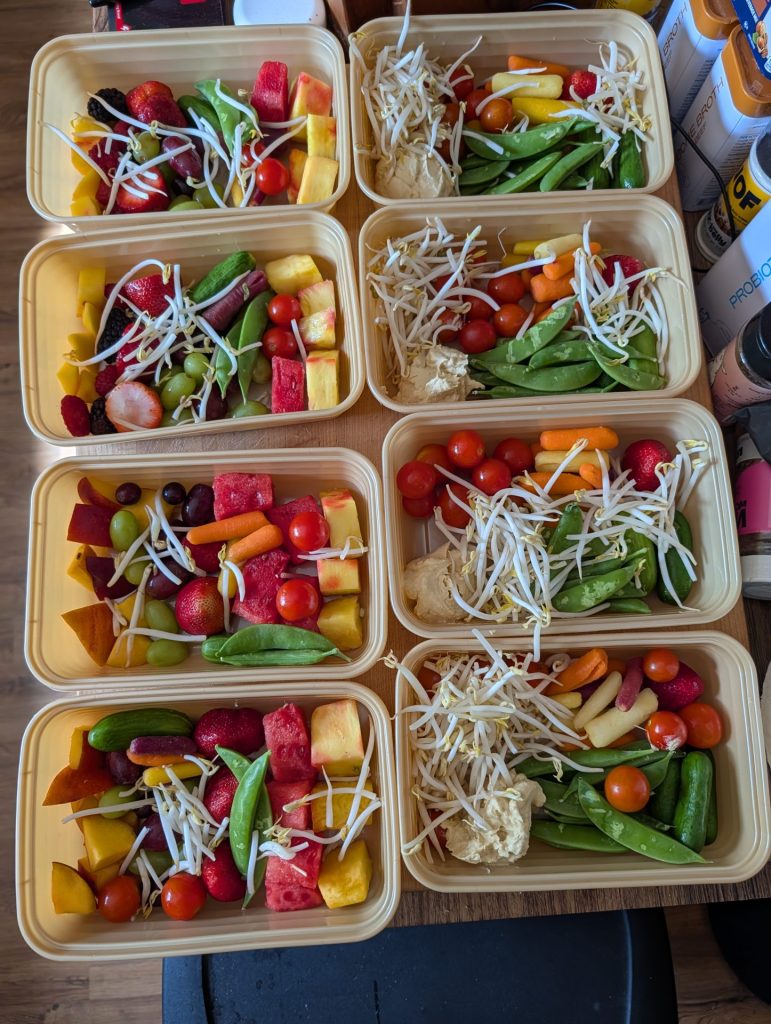 Eight to-go containers filled with a variety of fruits and vegetables